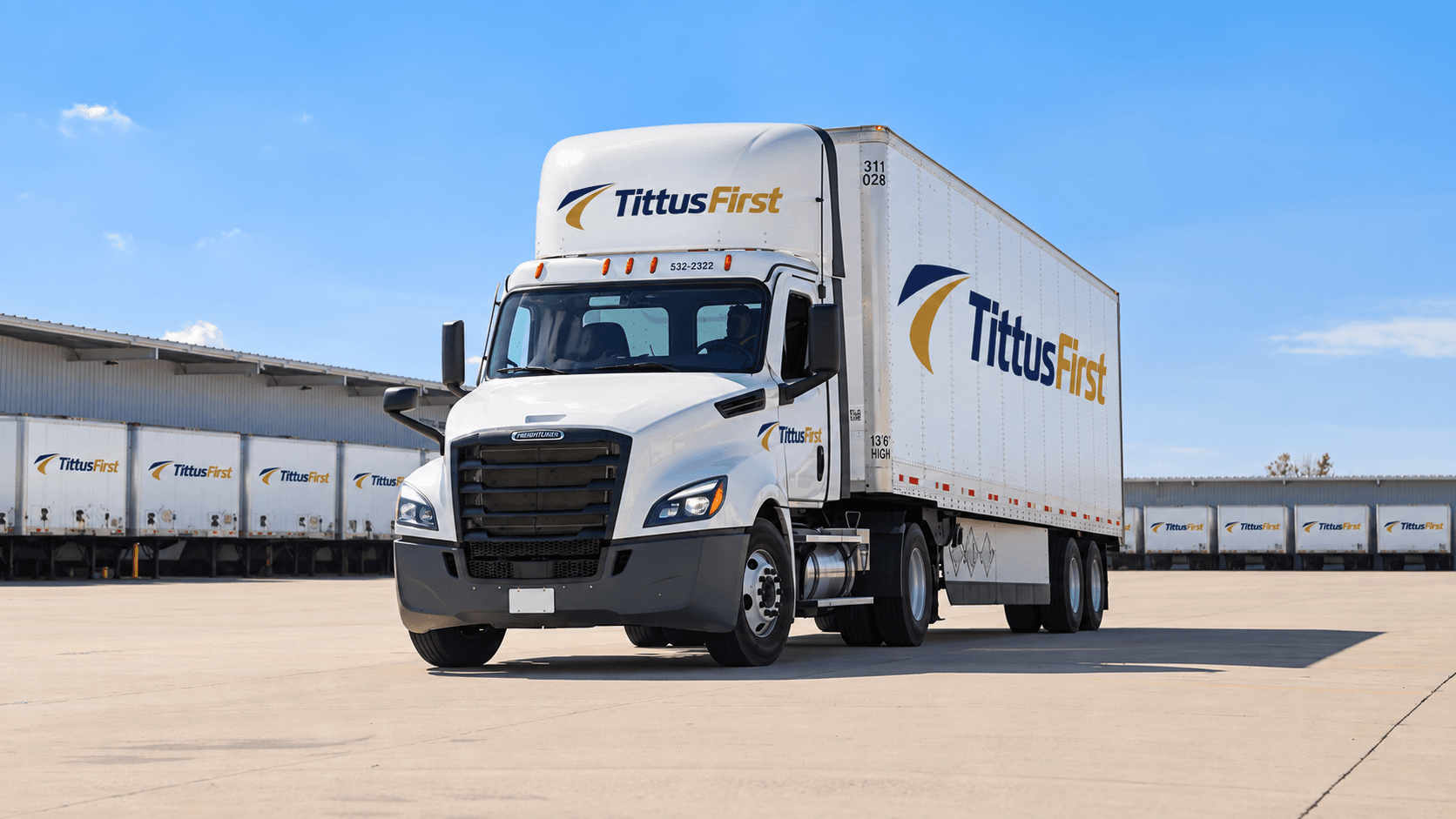 Tittus First tractor-trailer with branded cab and trailer at a freight terminal